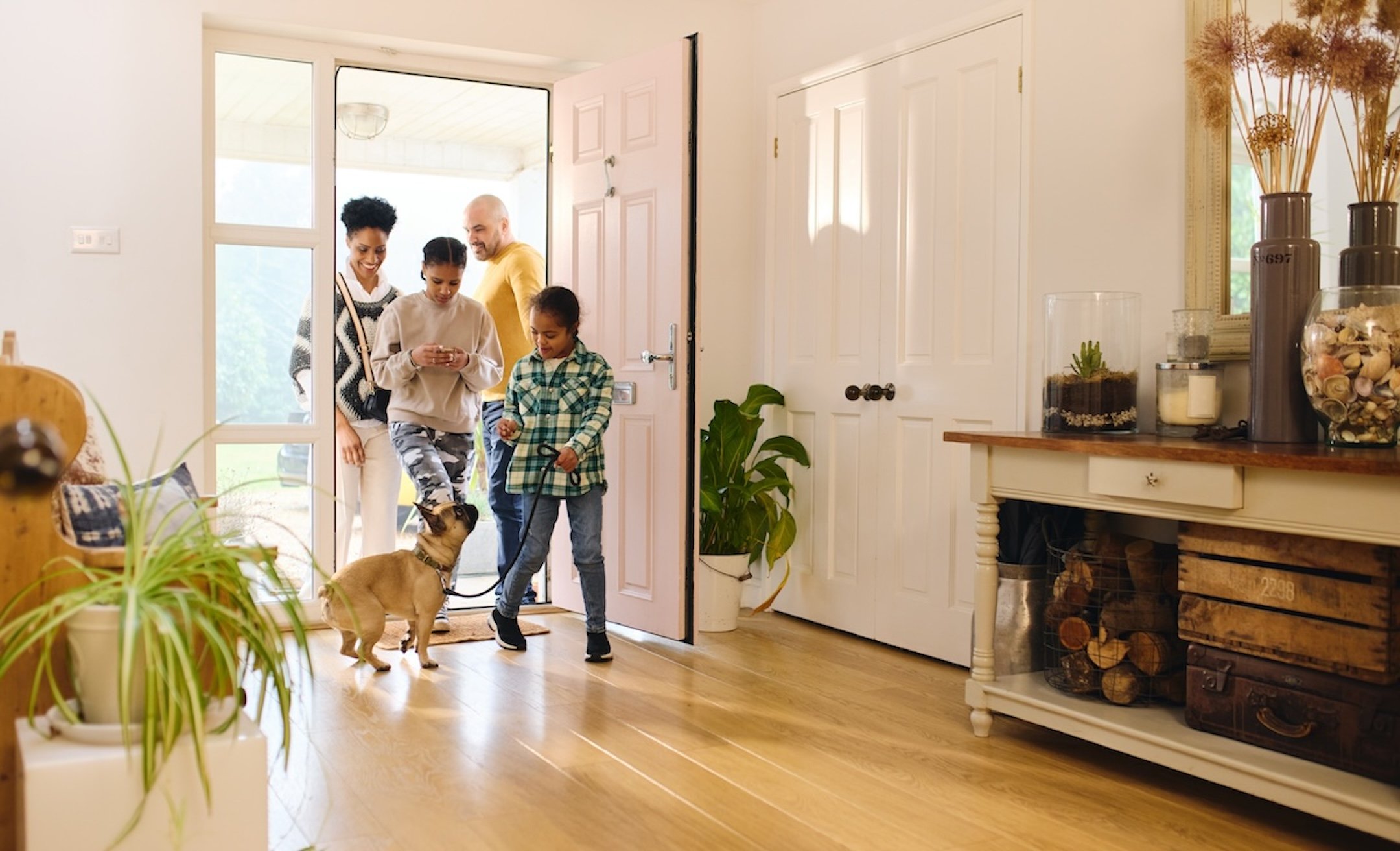 Family arriving home with dog