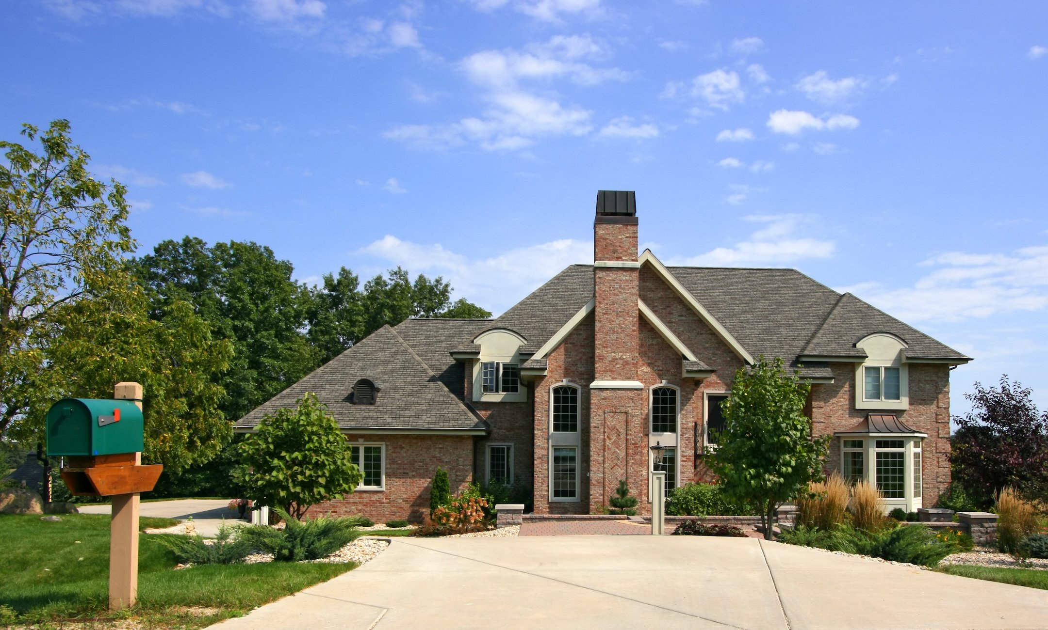 Luxurious home with blue sky and mailbox