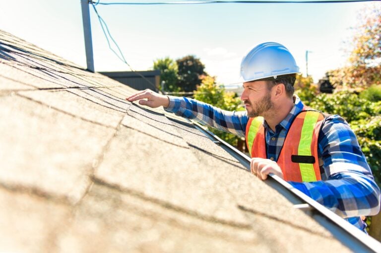 a man in a hard hat pointing at a roof